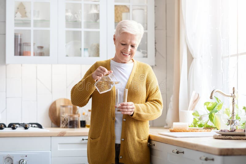 senior woman pouring herself a glass of water