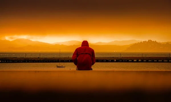 depressed man staring into the sunset